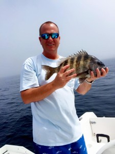 Alan Folsom from Valdosta with one of many sheepshead his family brought to the cleaning table. 